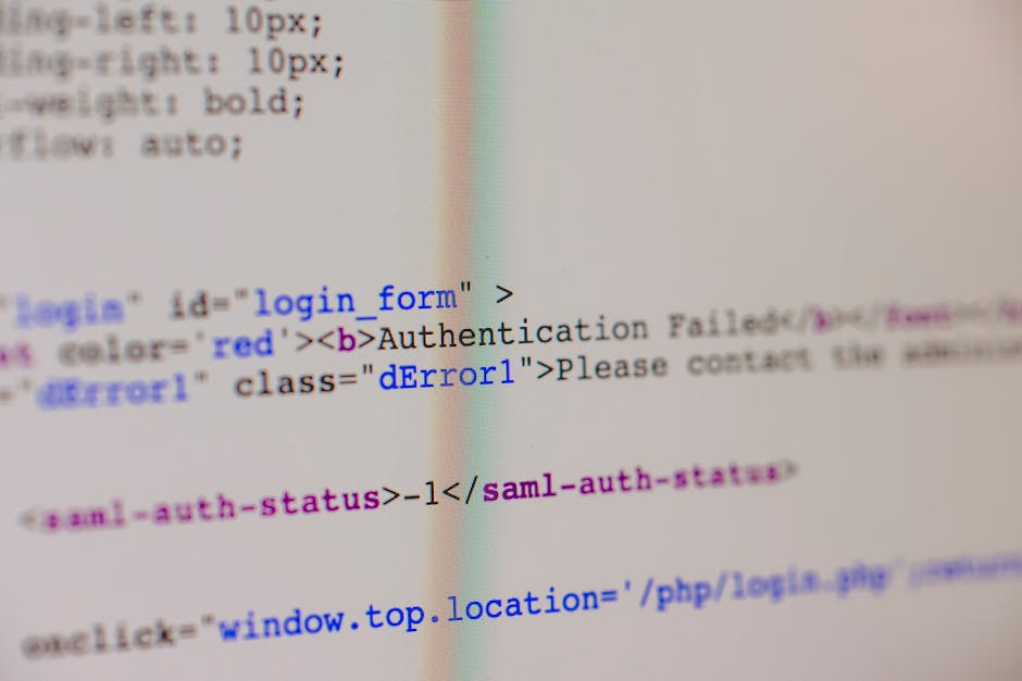 In the image, a computer screen displays a blurred close-up of a web development code editor with visible HTML and CSS syntax, including tags like 'login form' and 'error1', with various lines of code in blue, purple, and black text on a light background. The text appears slightly out of focus, showing the structure of a webpage's code rather than any physical scene or objects related to rubbish removal. The surrounding environment is not visible, and no physical objects, vehicles, or waste materials are evident in the image. This visual emphasizes digital content rather than the physical process of rubbish collection, which could relate to online management or booking systems for waste services, but the primary focus remains on the code itself, making it relevant to technical or administrative aspects of waste management without depicting actual rubbish or equipment.